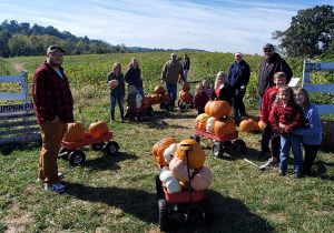 A family gathering their pumpkins