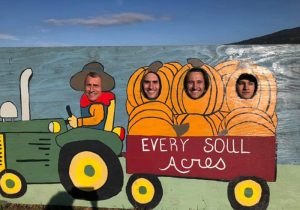 A family takes a funny photo with our "be a pumpkin" backdrop
