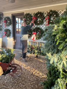 Laura hanging up our array of holiday wreaths